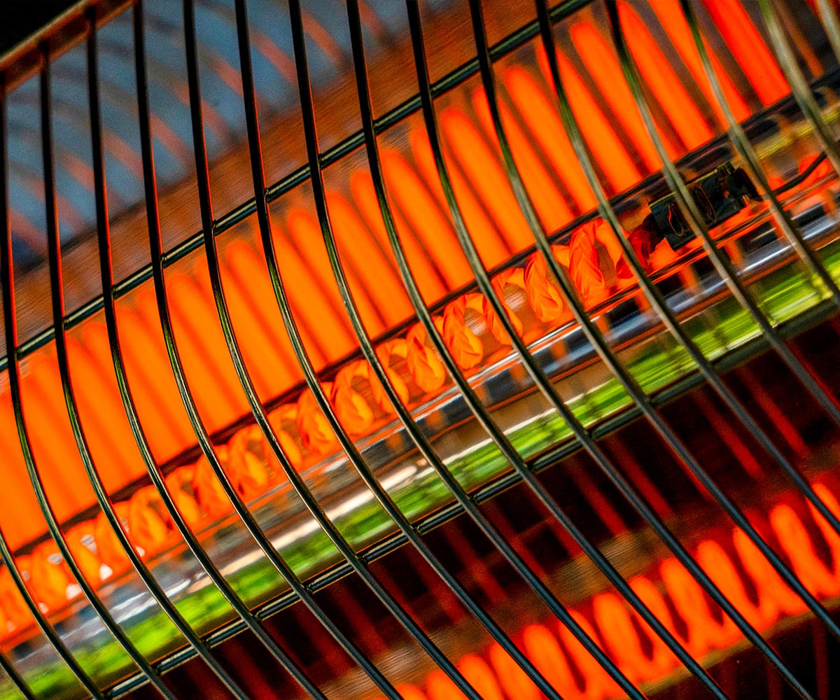 Close-up of the glowing heating element behind the heater's protective grille